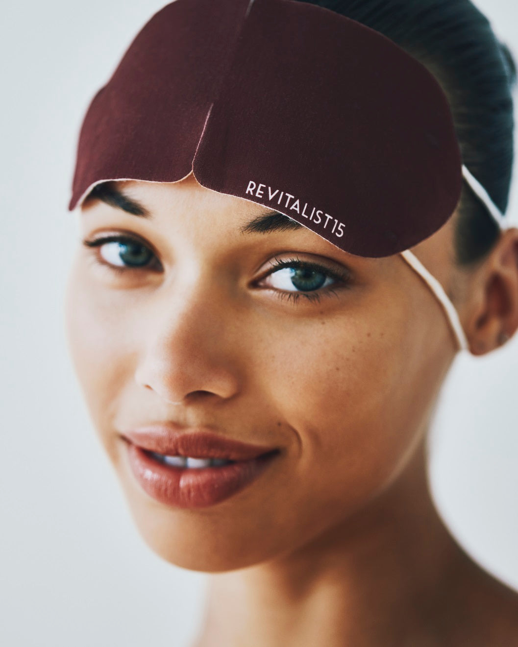 Model wearing Revitalist15 self-heating eye mask, demonstrating relaxation ritual