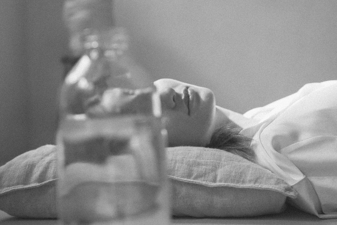 Person reclining on a pillow seen through a glass bottle, symbolizing a mindful pause and the restorative power of a 15-minute break.